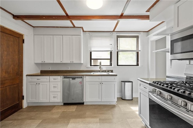 kitchen with appliances with stainless steel finishes, a sink, white cabinetry, coffered ceiling, and light floors