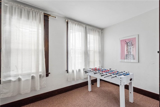 recreation room with carpet floors and baseboards