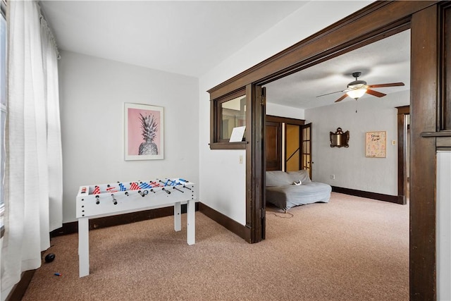 rec room featuring carpet, baseboards, and ceiling fan