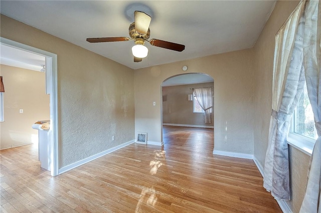 110 Orin St, Penn Hills, PA 15235 - empty room featuring arched walkways, a ceiling fan, plenty of natural light, light wood-type flooring, and a textured wall