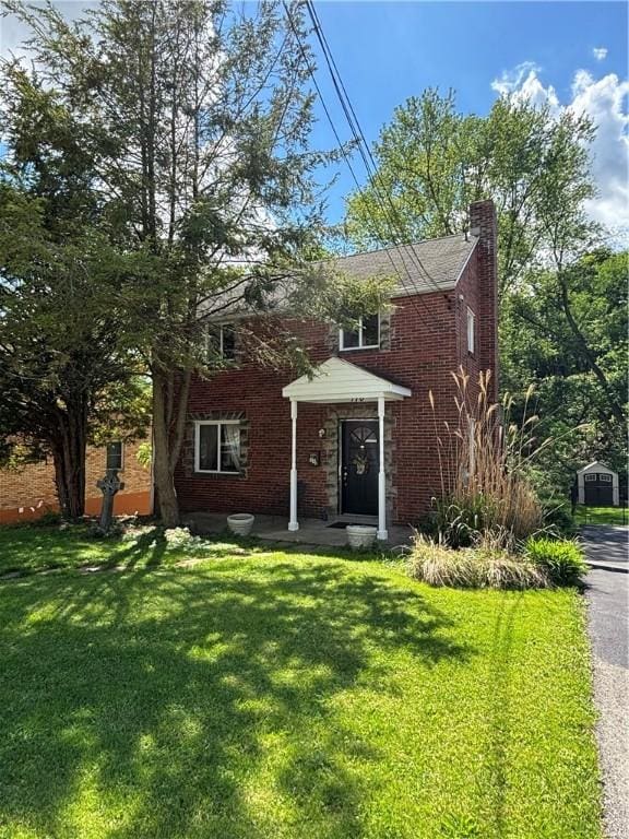110 Orin St, Penn Hills, PA 15235 - traditional-style home with a chimney, brick siding, and a front yard