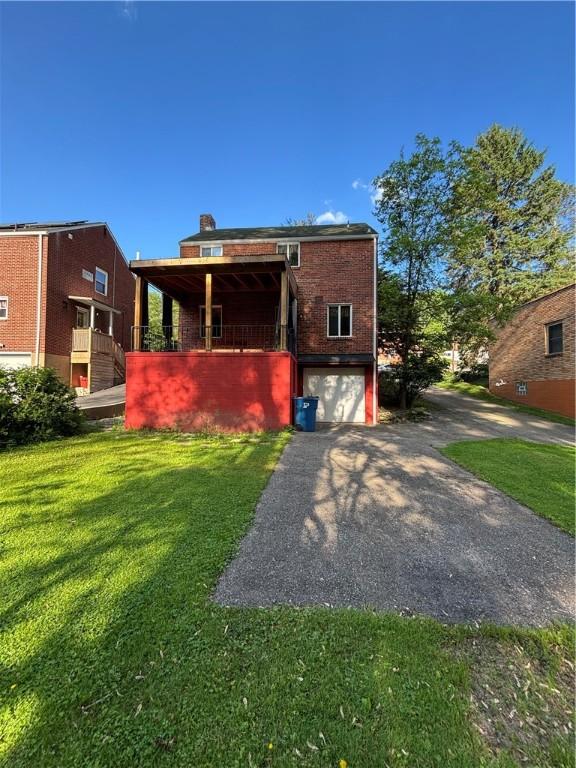110 Orin St, Penn Hills, PA 15235 - back of house featuring driveway, a garage, a lawn, and brick siding