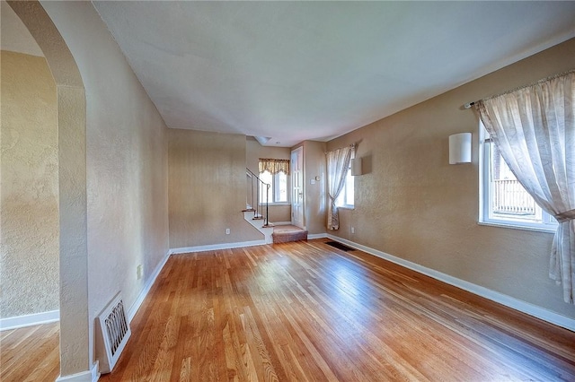 110 Orin St, Penn Hills, PA 15235 - empty room with a textured wall, wood finished floors, baseboards, stairs, and arched walkways
