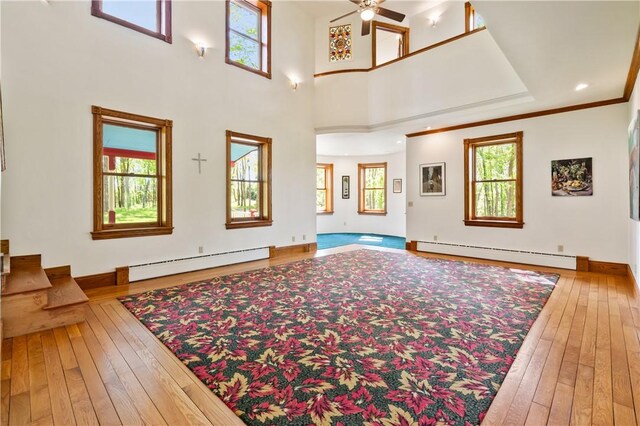 111 Pine Haven Dr, Donegal Twp But, PA 16034 - unfurnished living room with baseboard heating, hardwood / wood-style flooring, a ceiling fan, and baseboards
