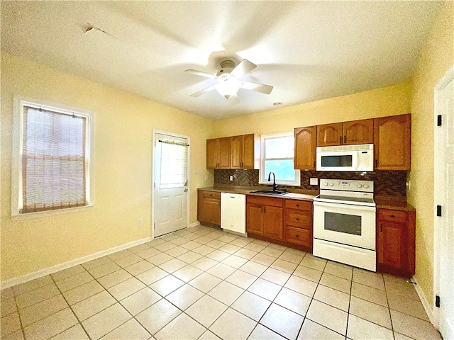 kitchen with white appliances, a sink, tasteful backsplash, ceiling fan, and light tile patterned flooring