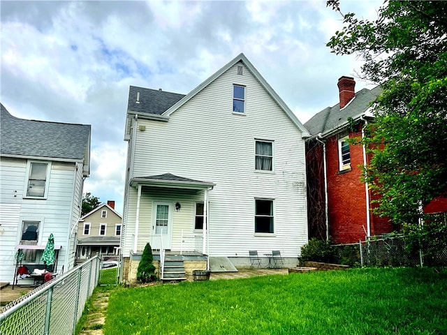 back of house featuring a shingled roof