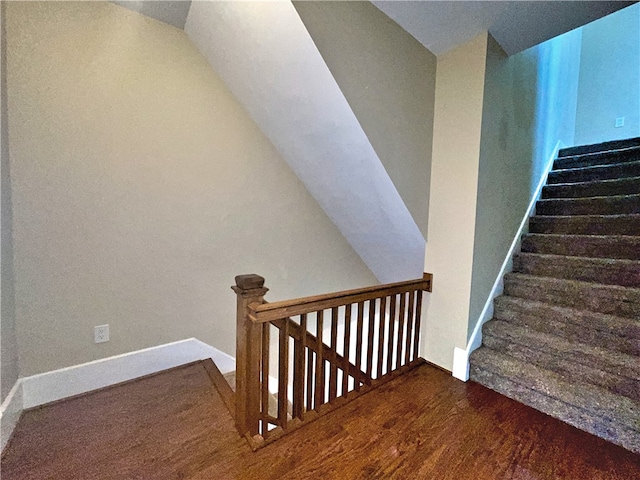 stairway with wood finished floors and baseboards