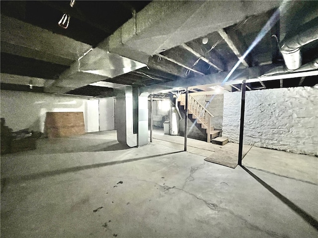unfinished basement featuring stairs, water heater, and heating unit
