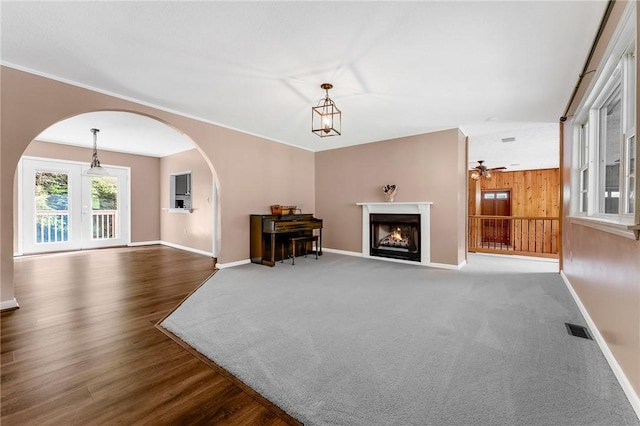 431 Mount Morris Rd, Kirby/Mtmorris, PA 15349 - living area with arched walkways, baseboards, a warm lit fireplace, wood finished floors, and wooden walls