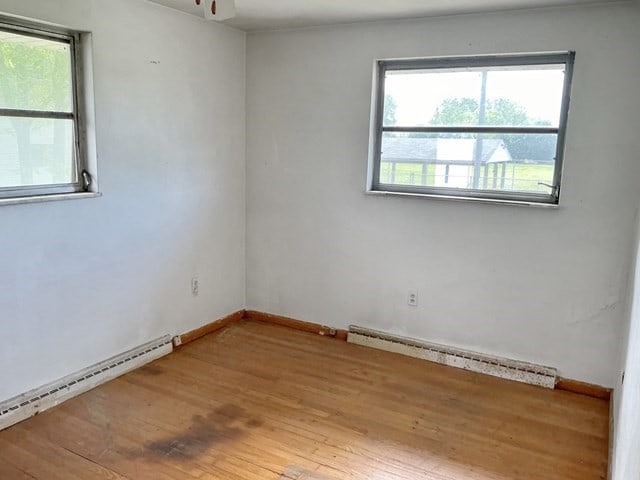13 Schoen St, Mckees Rocks, PA 15136 - spare room featuring a baseboard heating unit, baseboard heating, wood finished floors, baseboards, and a ceiling fan