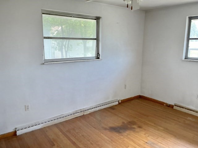 13 Schoen St, Mckees Rocks, PA 15136 - spare room with a baseboard radiator, wood finished floors, a ceiling fan, and baseboards