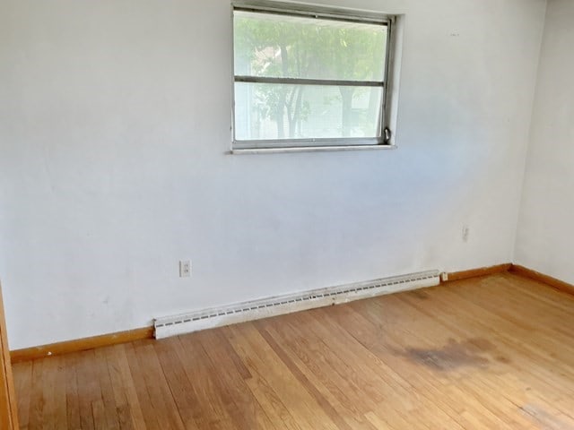 13 Schoen St, Mckees Rocks, PA 15136 - spare room with baseboard heating, wood finished floors, and baseboards