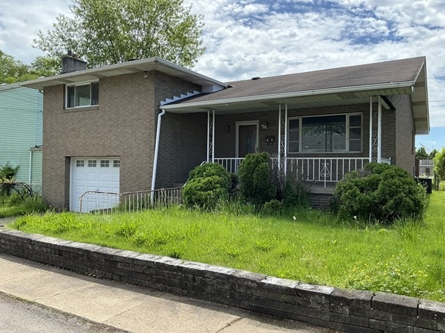 13 Schoen St, Mckees Rocks, PA 15136 - tri-level home featuring an attached garage, a porch, and a chimney