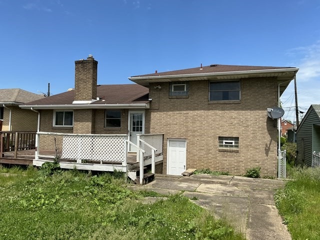 13 Schoen St, Mckees Rocks, PA 15136 - rear view of property with a chimney, a wooden deck, and brick siding