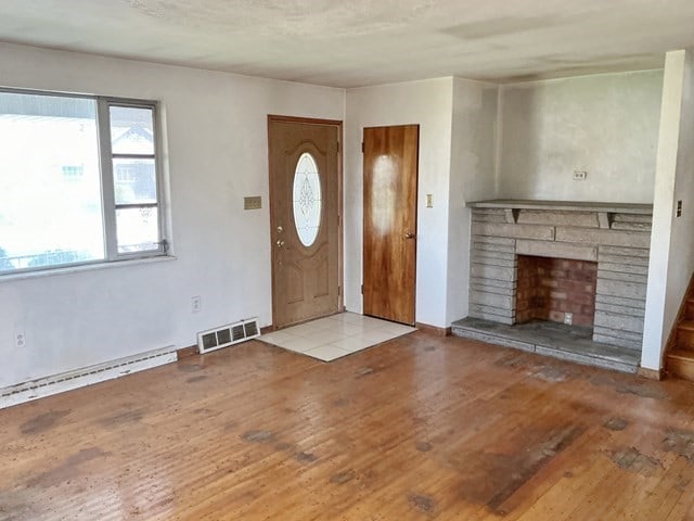 13 Schoen St, Mckees Rocks, PA 15136 - entryway featuring wood-type flooring, a fireplace with raised hearth, and a baseboard heating unit