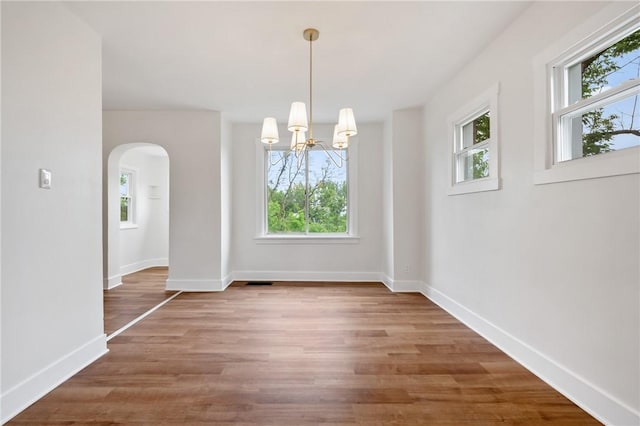 123 Bascom Ave, Observatory Hill, PA 15214 - unfurnished dining area with arched walkways, healthy amount of natural light, a chandelier, and wood finished floors