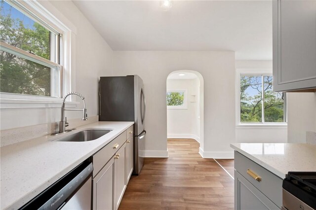 123 Bascom Ave, Observatory Hill, PA 15214 - kitchen with a sink, appliances with stainless steel finishes, light wood-type flooring, baseboards, and light stone counters
