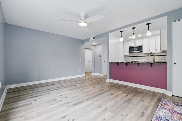 3289 Dawson St Unit 1, Oakland, PA 15213 - unfurnished living room featuring a ceiling fan, light wood-style floors, baseboards, and a sink