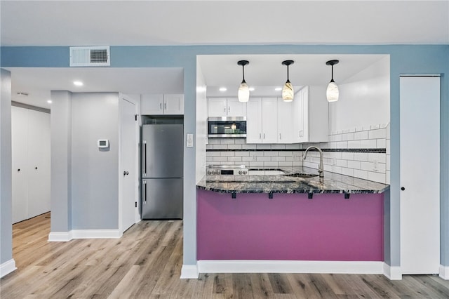3289 Dawson St Unit 1, Oakland, PA 15213 - kitchen featuring stainless steel appliances, a sink, dark stone countertops, white cabinetry, and a kitchen bar