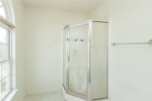 full bath featuring a shower stall, healthy amount of natural light, and baseboards