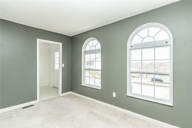 unfurnished room with carpet flooring and baseboards