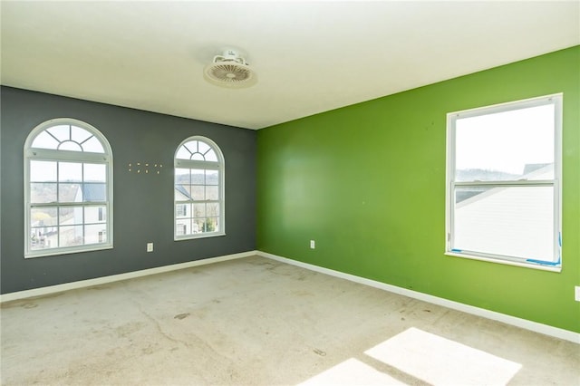 spare room featuring baseboards and carpet floors