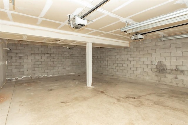 garage featuring a garage door opener and concrete block wall