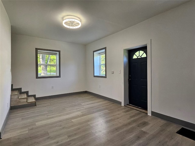 entrance foyer with wood finished floors, baseboards, and stairs