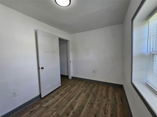 unfurnished bedroom featuring dark wood-style floors and baseboards