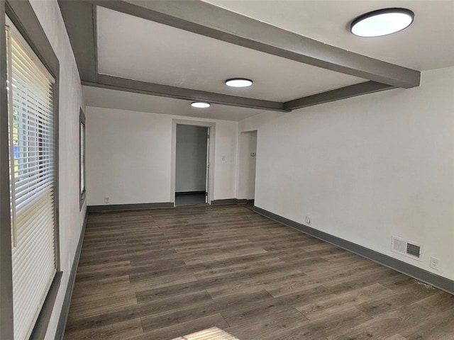 unfurnished bedroom featuring beamed ceiling, dark wood-style flooring, and baseboards
