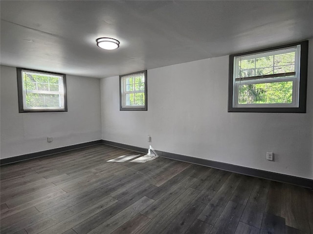 empty room featuring dark wood finished floors and baseboards