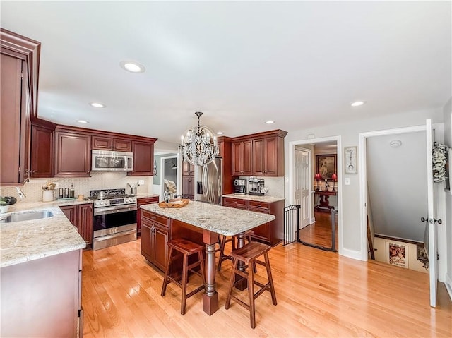 2388 Mill Grove Rd, Upper St Clair, PA 15241 - kitchen with stainless steel appliances, a sink, a chandelier, a center island, and tasteful backsplash