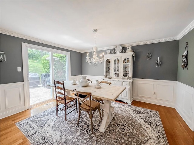 2388 Mill Grove Rd, Upper St Clair, PA 15241 - dining space with a wainscoted wall, a chandelier, light wood finished floors, crown molding, and a decorative wall