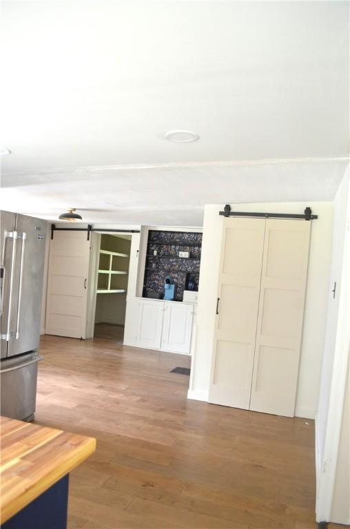 218 S Mercer, Linesville Boro, PA 16424 - unfurnished living room featuring a barn door and wood finished floors