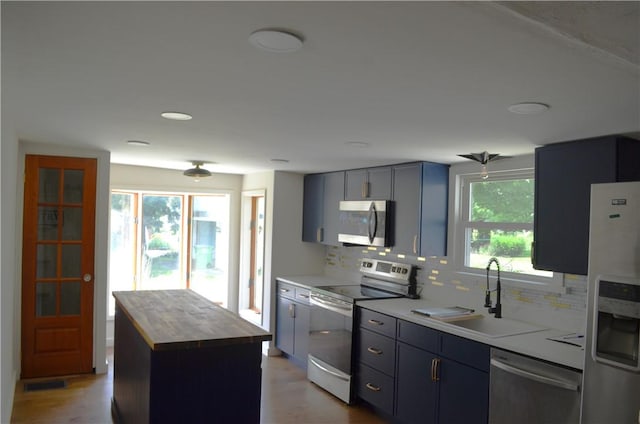 218 S Mercer, Linesville Boro, PA 16424 - kitchen with appliances with stainless steel finishes, wood counters, decorative backsplash, and light wood-style floors