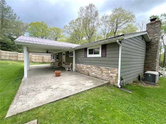 643 Laurel Summit Rd, Jenner Twp, PA 15531 - view of side of property featuring a ceiling fan, a chimney, stone siding, metal roof, and a patio area