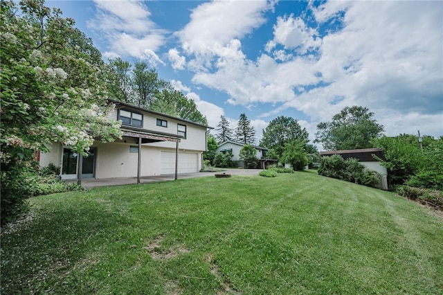 103 Shady Dr, White Twp Ind, PA 15701 - view of grassy yard with an attached garage, driveway, and a patio area
