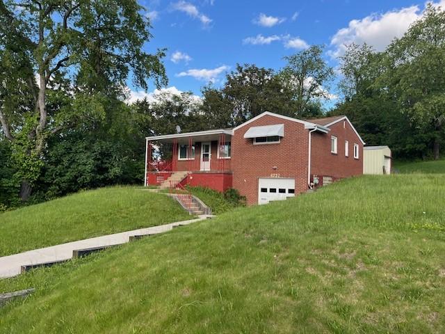 6729 Highland Ave, Union Twp Wsh, PA 15332 - view of front of property featuring a garage, brick siding, a front lawn, and driveway