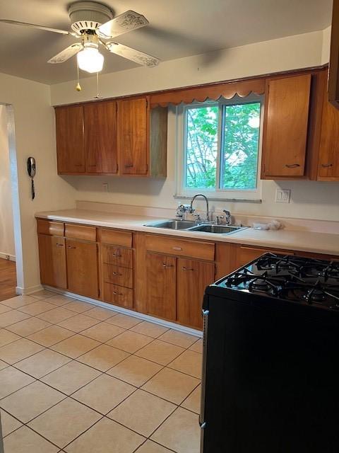 6729 Highland Ave, Union Twp Wsh, PA 15332 - kitchen featuring black range with gas cooktop, brown cabinetry, a sink, light countertops, and ceiling fan