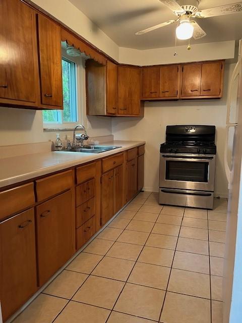 6729 Highland Ave, Union Twp Wsh, PA 15332 - kitchen with gas stove, a sink, light countertops, brown cabinets, and light tile patterned floors