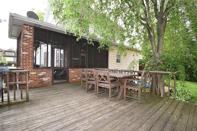 deck with outdoor dining space and a sunroom