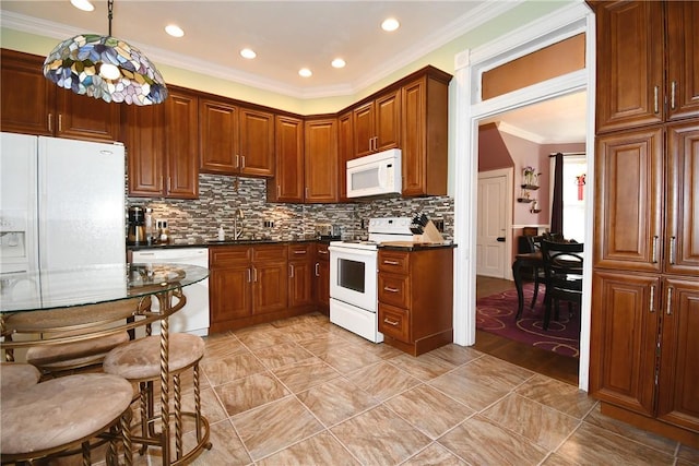kitchen with white appliances, crown molding, dark countertops, backsplash, and a sink