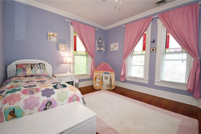 bedroom with wood finished floors, crown molding, multiple windows, and baseboards