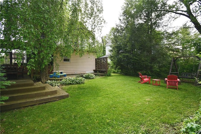 view of green lawn featuring a wooden deck