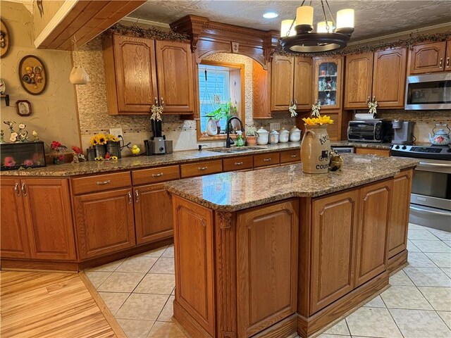 2650 Georgeville Rd, S Mahoning/Plumville, PA 15759 - kitchen featuring stainless steel appliances, a sink, brown cabinets, decorative backsplash, and ornamental molding