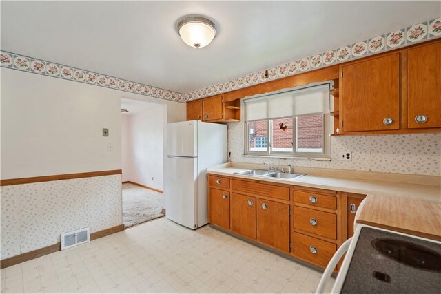 106 High St, Elizabeth Twp/Boro, PA 15037 - kitchen featuring freestanding refrigerator, a sink, electric range oven, brown cabinetry, and wallpapered walls