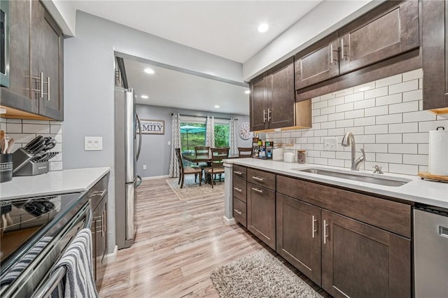 436 Allenberry Dr, Ross Twp, PA 15237 - kitchen with a sink, appliances with stainless steel finishes, light wood-style floors, backsplash, and dark brown cabinets