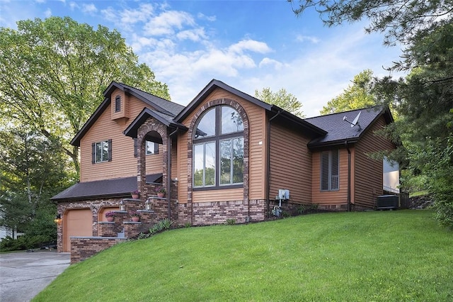 view of front facade featuring driveway, a garage, a front yard, and central air condition unit