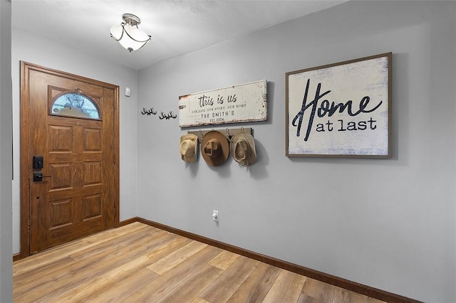 entryway featuring baseboards and wood finished floors