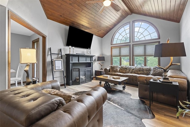living room with a ceiling fan, wood finished floors, vaulted ceiling, a fireplace, and wooden ceiling
